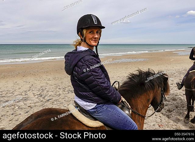 Hirtshals, Denmark A middle-aged woman goes horseback riding on the beach