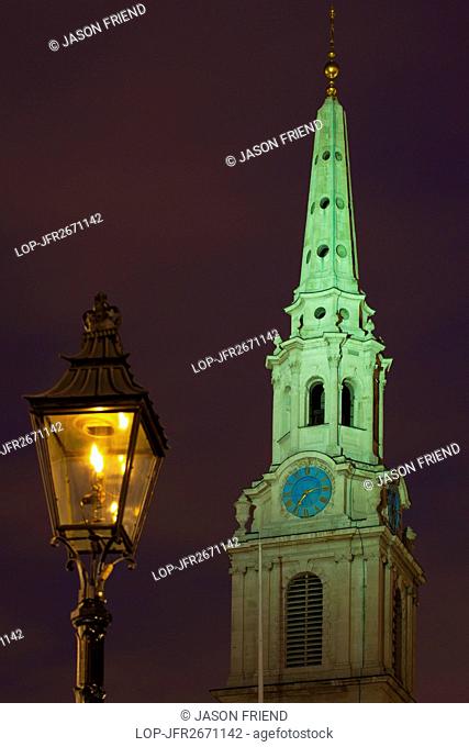 England, London, Traflagar Square. Flame lit street lamp and the church spire of St Martin-in-the-Fields near Trafalgar Square, at dusk