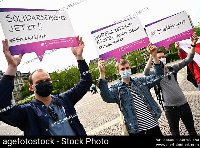 08 June 2020, Hessen, Wiesbaden: During a rally of the Hessian student representatives, students hold posters with the inscription (l-r) ""Solidarity semester...