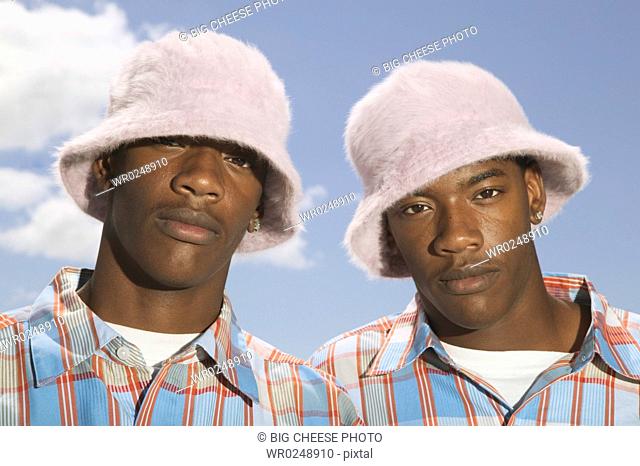 Twin teenage boys in matching hats and shirts