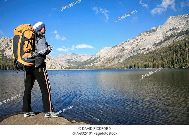 A hiker takes in the view on the shore of Tenaya Lake, in the Tuolumne Meadows, near Tioga Pass and Yosemite Valley, Sierra Nevada, California