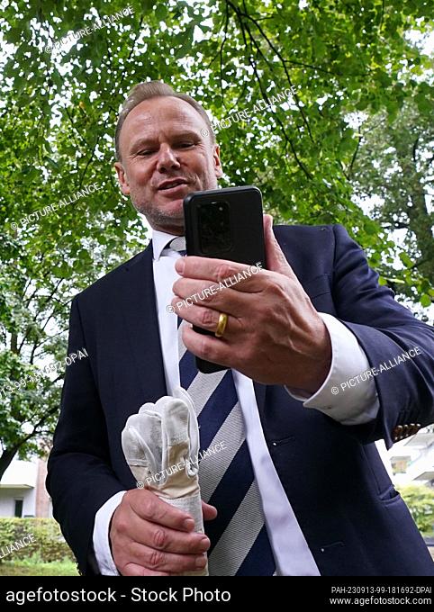 13 September 2023, Hamburg: Andy Grote (SPD), Senator for the Interior and Sport in Hamburg, looks at his smartphone after a press appointment to dismantle the...