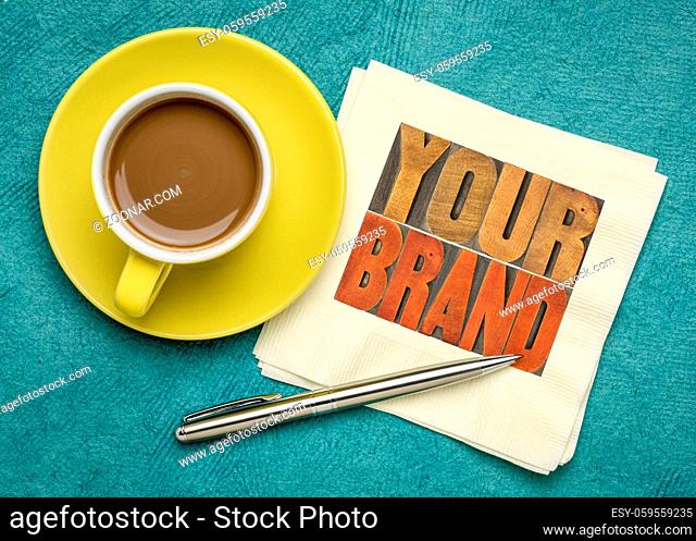 your brand word abstract- motivational concept in vintage letterpress wood type block on a napkin with a cup of coffee, identity and business marketing concept