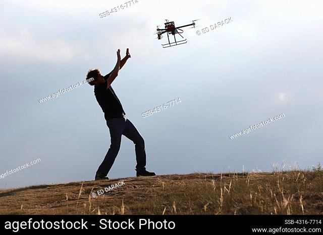 Man pleading with unmanned aerial vehicle (UAV) or drone, That is pursuing him
