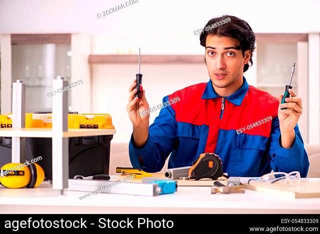 The young contractor repairing furniture at home