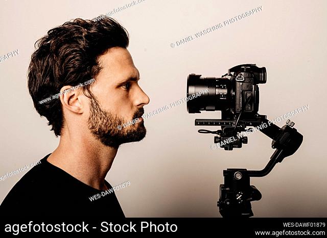 Bearded man looking at camera by beige background