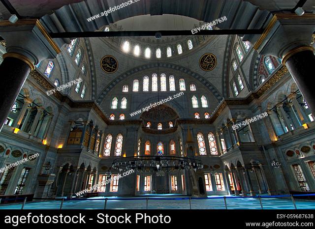 Interior of Nuruosmaniye Mosque, Istanbul, Turkey, with huge arches, decorated domes and colored stained glass windows