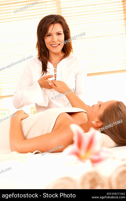 Female masseur doing hand massage in massage salon