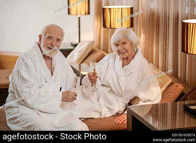Anniversary celebration. A senior couple drinking wine and looking happy