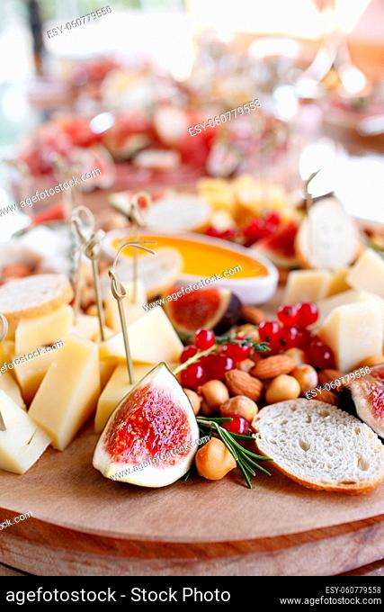 Assortment of cheese on wooden board. a buffet table at a party outdoors