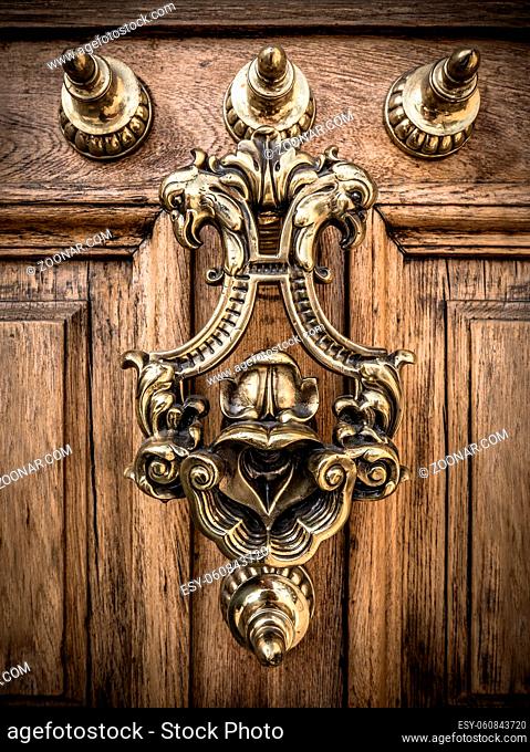 A Grand Ornate Brass Door Knocker On A Heavy Wooden Door In Spain