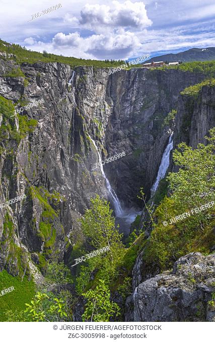 Waterfall Voringfossen and its ravine in the canyon of Mabodalen, Norway, with the known Fossli Hotel above, also called Voringsfossen