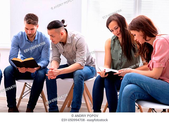 Group Of Friend Sitting Together On Chair Reading Bible
