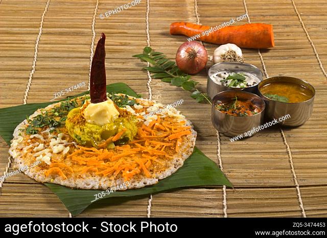 Thick spongy dosas served together with coconut chutney and sambhar on banana leaf