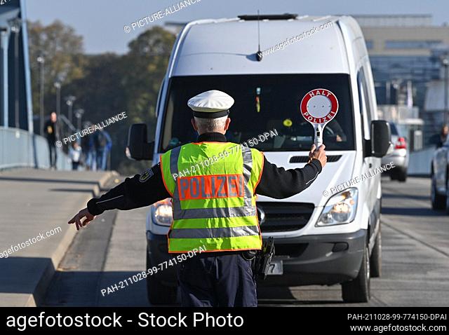 28 October 2021, Brandenburg, Frankfurt (Oder): A Federal Police officer stops a driver of a van entering Germany at the German-Polish border crossing...