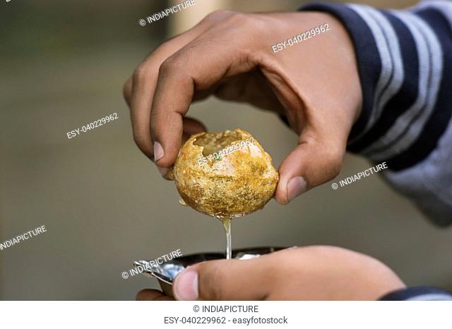 Close-up of man holding panipuri served in a bowl