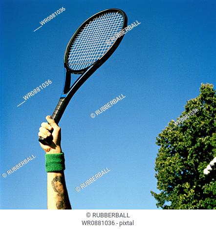 Low angle view of a young man holding a tennis racket