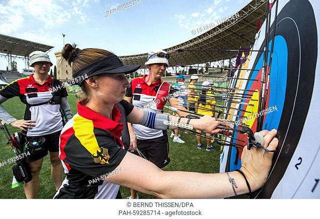 Germany's Lisa Unruh (R), Karina Winter (C) and Elena Richter check the target during practise session prior the Archery Women's Team quarterfinal at the Baku...