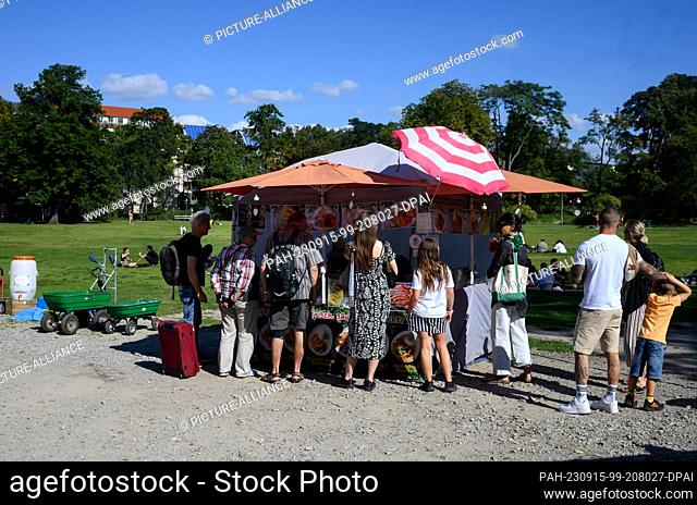 15 September 2023, Berlin: Market visitors stand by a mobile kitchen at the Thai street food market in Preußenpark in Berlin-Wilmersdorf