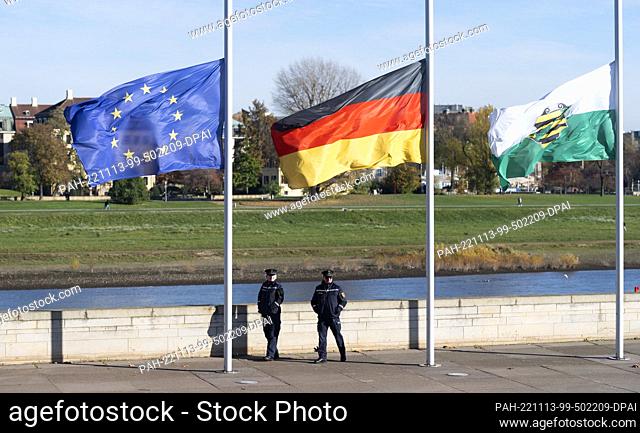 13 November 2022, Saxony, Dresden: The flags of Europe, Germany and Saxony are flown at half-mast in front of the state parliament building