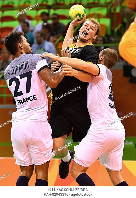 Paul Drux (C) of Germany and Adrien Dipanda (L) of France in action during the Men's Semifinal match between France and Germany of the Handball events during...