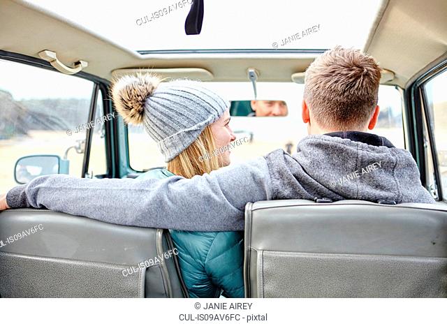 Rear view of young couple in car at beach