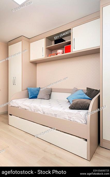 Modern beige bedroom with wardrobe and sofa