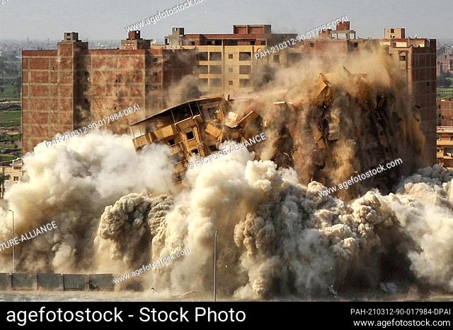 12 March 2021, Egypt, Kafr Tohormos: A 14-story building collapses during a controlled explosion operation carried out by Egyptian authorities to bring down the...
