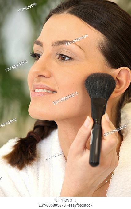 Woman applying blush with a brush