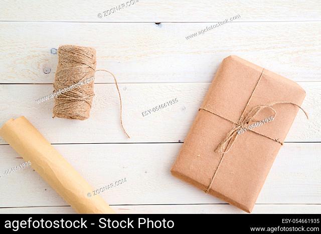 parcel, gift Packed in eco-friendly paper and twine for packing on light wooden background. the view from the top