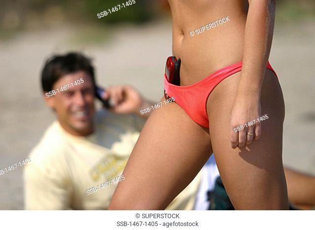 young woman pulling down bikini bottom to reveal tan line, Stock Photo, Pic...