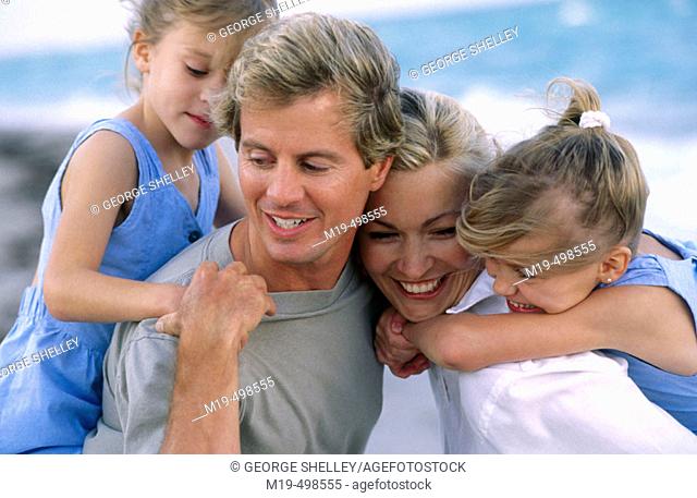 Mom & dad with twin girls at the beach