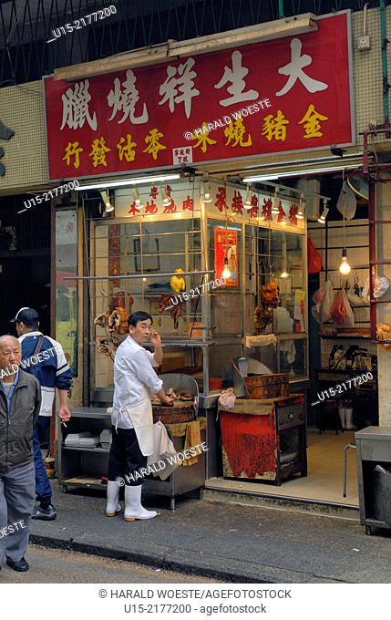 Hong Kong, China, Asia. Hong Kong Kowloon. Roadside butcher using a telephone while working