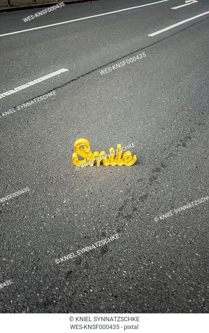 The word 'Smile' on empty street