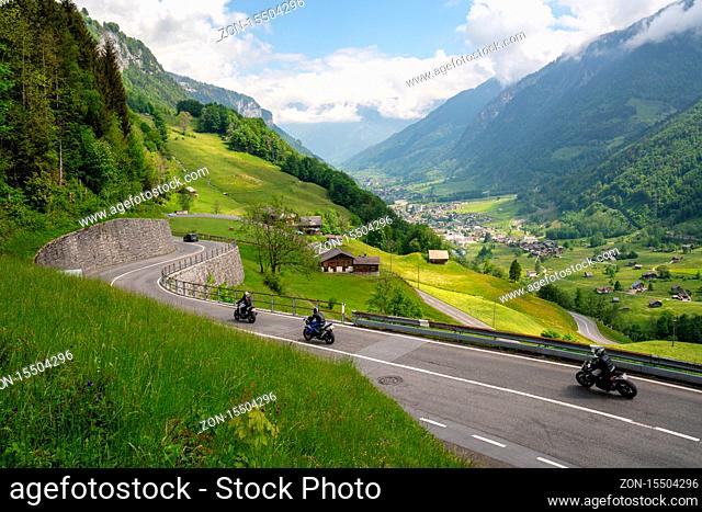 Linthtal, GL / Switzerland - 17 May 2020: A view of many motorcycles racing down the curvy Klausenpass mountain road in the Swiss Alps near Glarus