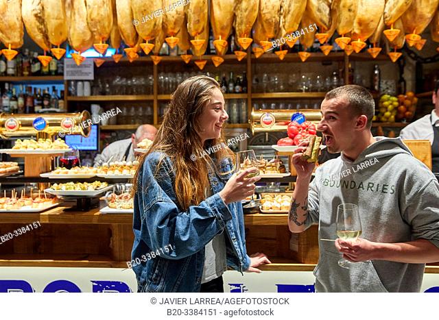 Young couple eating "Pintxos" at the Meson Portaletas, Parte Vieja, Old town, Donostia, San Sebastian, Gipuzkoa, Basque Country, Spain