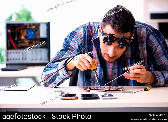 The young handsome technician repairing mobile phone