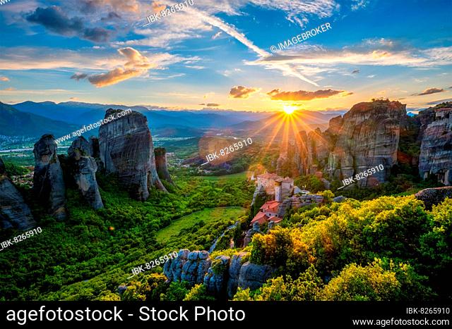 Sunset over monastery of Rousanou and Monastery of St, Nicholas Anapavsa in famous greek tourist destination Meteora in Greece on sunset with sun rays and lens...