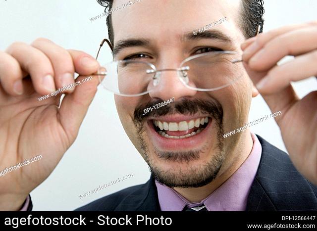 Portrait of a businessman holding eyeglasses and smiling