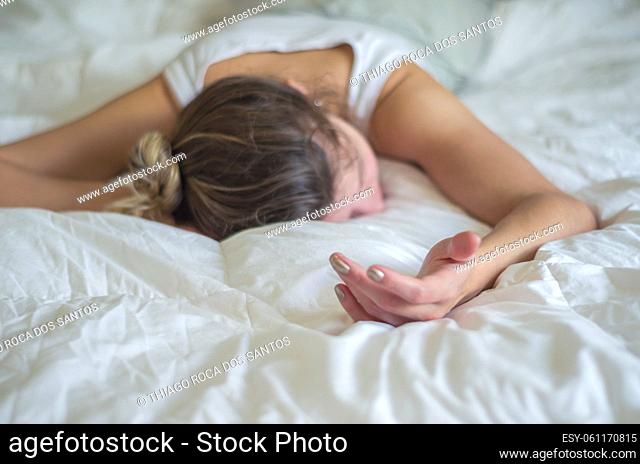 Young woman, blond hair, fainted in bed
