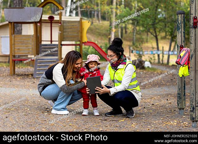 Preschool teachers with student at playground