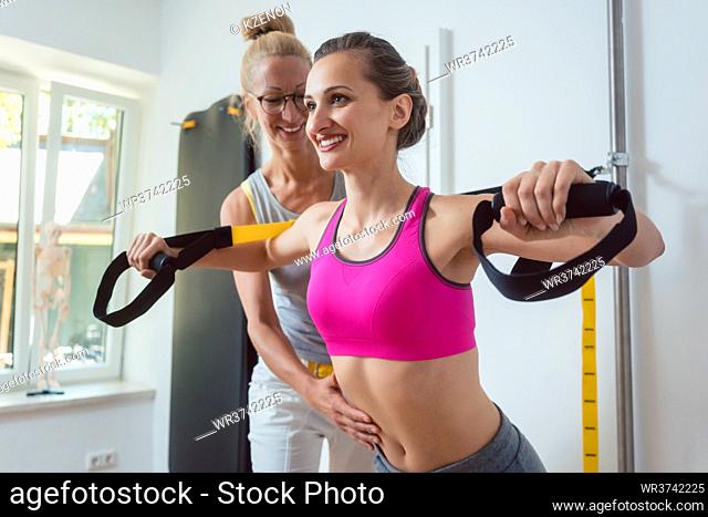 Woman using sling trainer during physical therapy