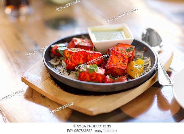 close up of paneer tikka dish with sauce on table
