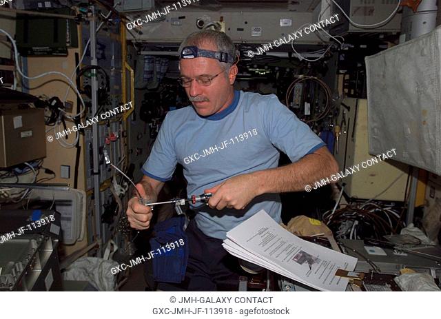 Astronaut John L. Phillips, Expedition 11 NASA ISS science officer and flight engineer, works with the Treadmill Vibration Isolation System (TVIS) during...