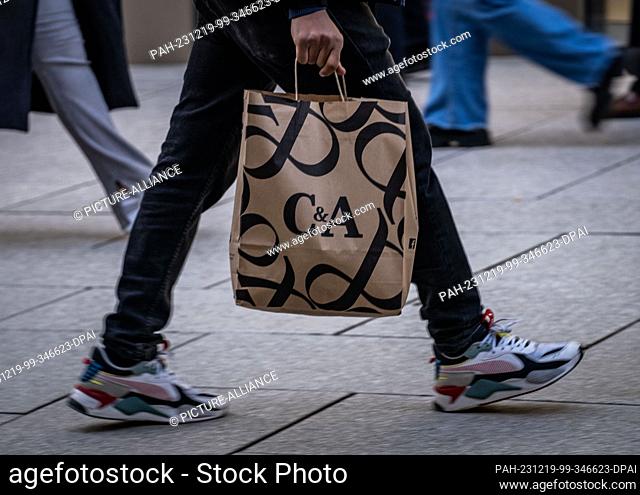 13 December 2023, Hesse, Frankfurt/Main: A passer-by carries a C&A bag along Frankfurt's Zeil shopping street. Photo: Frank Rumpenhorst/dpa