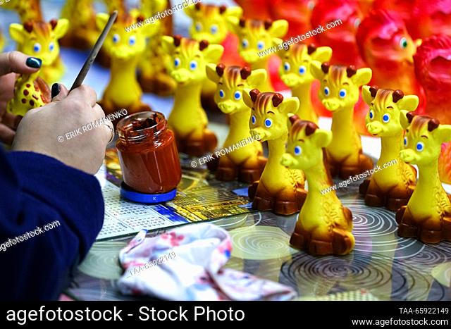 RUSSIA, VORONEZH - DECEMBER 19, 2023: An employee paints Christmas ornaments at the Igrushki factory. The enterprise is engaged in production of PVC plastisol...