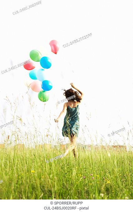 Woman with balloons running away