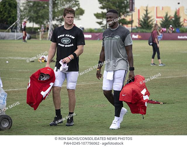 New York Jets quarterback Sam Darnold (14), left, and quarterback Teddy Bridgewater (5), right, converse as they walk off the field after participating in a...