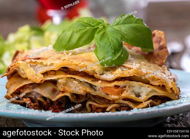 lasagna with salad on dark wood