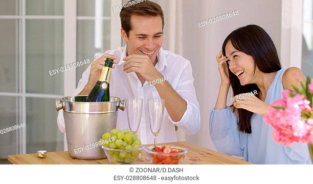Shocked young couple during champagne opening